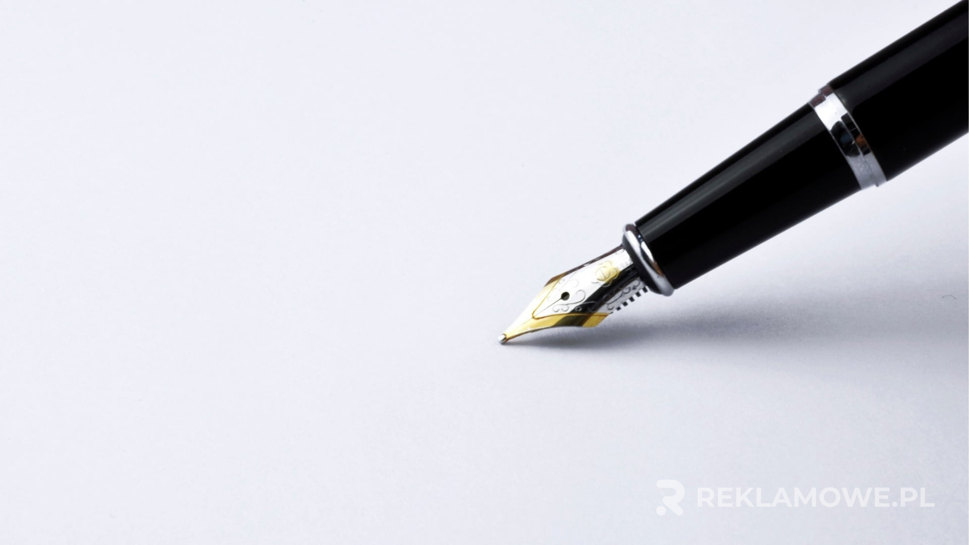 Pióra reklamowe na tle różnych gadżetów promocyjnych